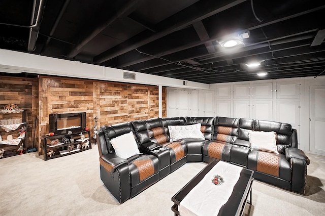 cinema room with carpet, visible vents, and wood walls