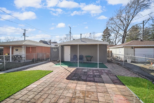 rear view of house with an outbuilding, fence, and a patio area