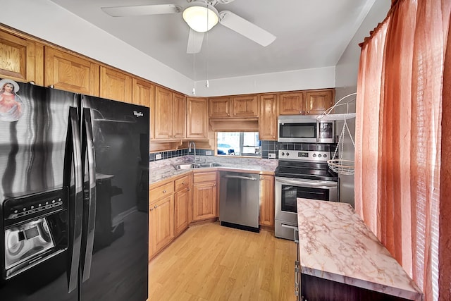 kitchen featuring light countertops, light wood finished floors, appliances with stainless steel finishes, and a sink