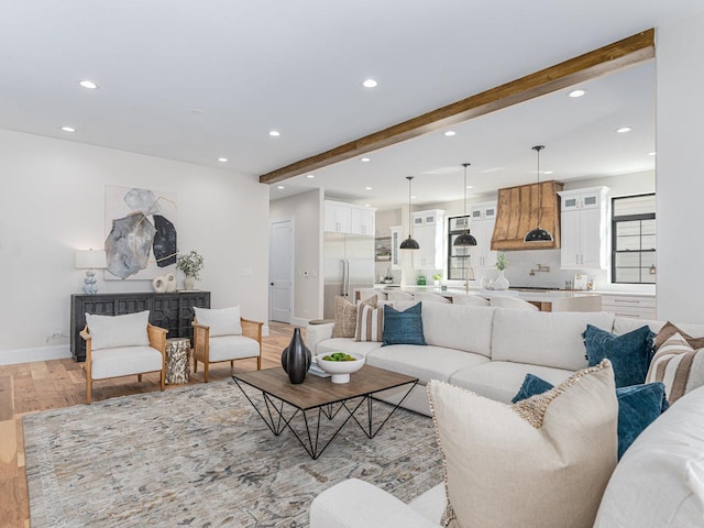 living room featuring beam ceiling, recessed lighting, baseboards, and light wood finished floors