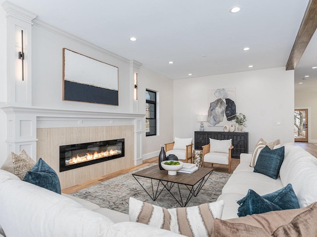 living area with recessed lighting, baseboards, wood finished floors, and a glass covered fireplace