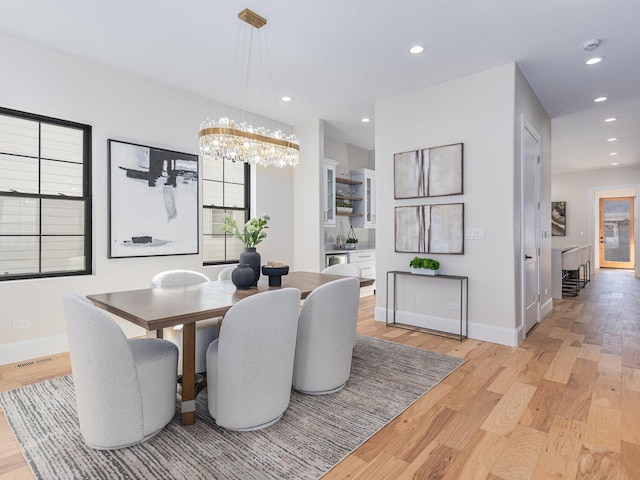 dining space with visible vents, baseboards, light wood-style flooring, recessed lighting, and a notable chandelier