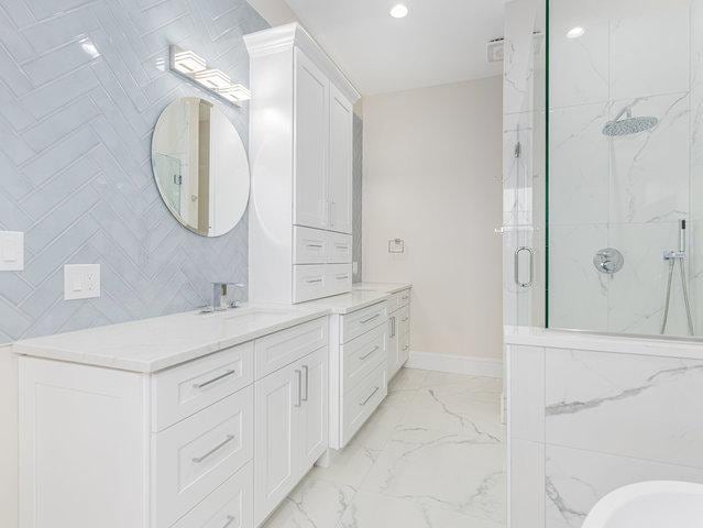 bathroom with vanity, baseboards, a marble finish shower, recessed lighting, and marble finish floor