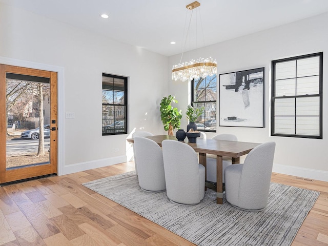 dining area featuring recessed lighting, light wood-type flooring, baseboards, and a chandelier