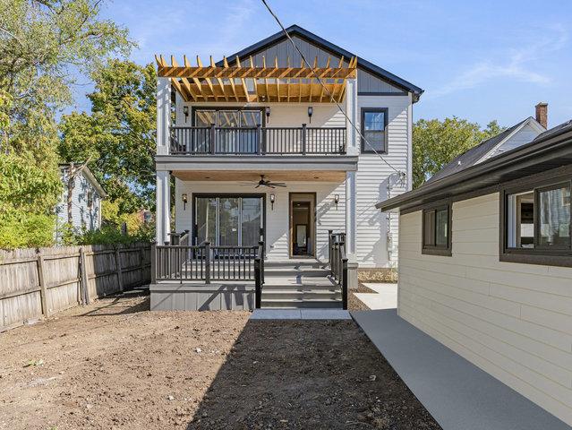 view of front of home with a balcony, covered porch, ceiling fan, and fence