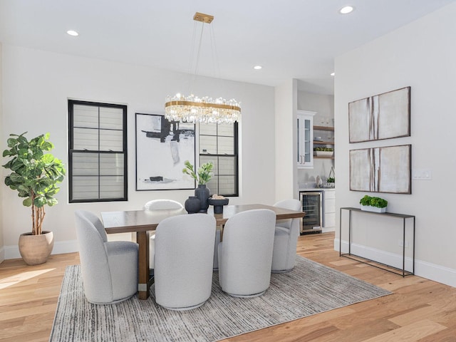 dining room featuring beverage cooler, a chandelier, recessed lighting, and light wood finished floors