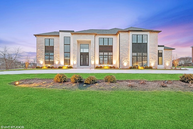 view of front of home with stone siding, stucco siding, and a front yard