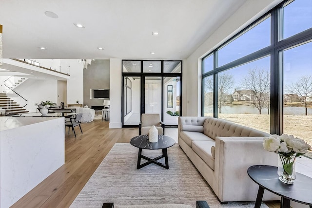 living area featuring recessed lighting, stairway, and light wood-style flooring