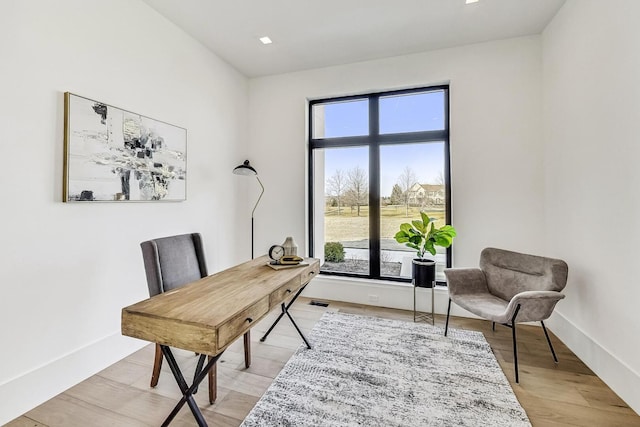 office space with baseboards and light wood finished floors