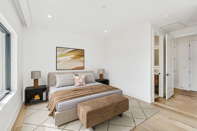 bedroom featuring baseboards, attic access, and light wood-style floors