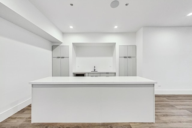 kitchen featuring light countertops, light wood-style flooring, modern cabinets, and a sink