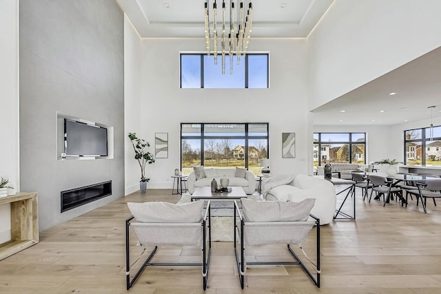 living room featuring a glass covered fireplace, recessed lighting, and wood finished floors