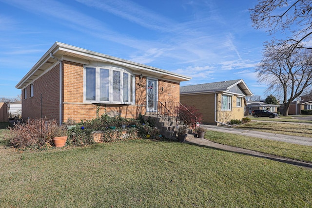 view of front of home with driveway, brick siding, and a front yard