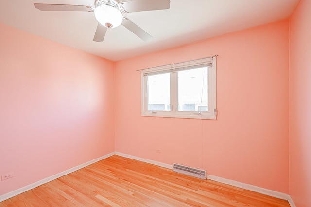 empty room with light wood-style floors, baseboards, and visible vents