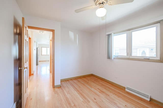 spare room featuring light wood-type flooring, visible vents, baseboards, and ceiling fan