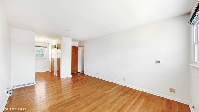 unfurnished room with light wood-style floors and baseboards