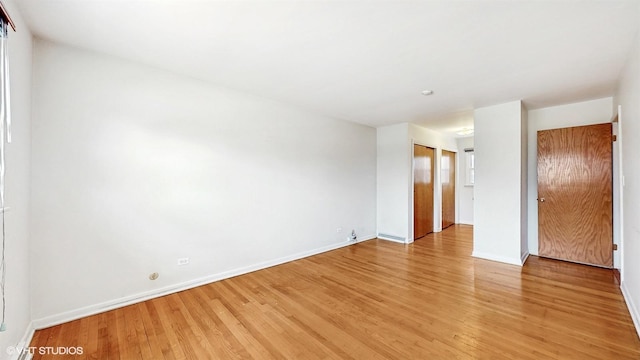 unfurnished room with light wood-style flooring and baseboards