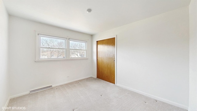 carpeted spare room featuring baseboards and visible vents