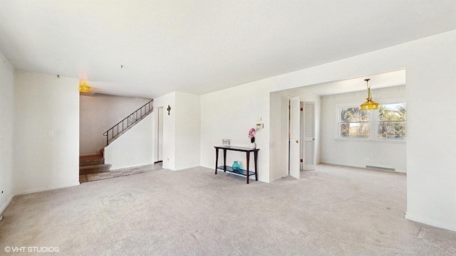 unfurnished living room featuring a baseboard radiator, carpet, and stairs