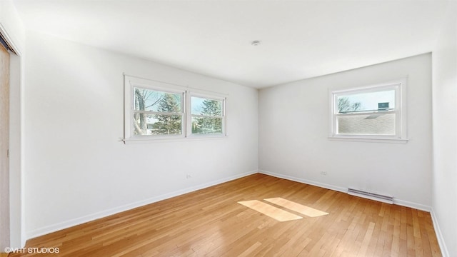 unfurnished room with visible vents, light wood-style flooring, and baseboards