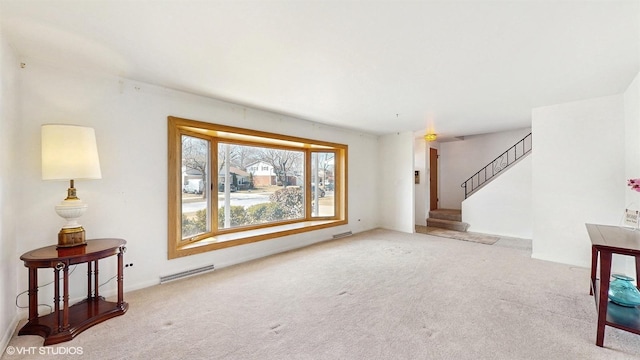 carpeted living area with visible vents and stairs