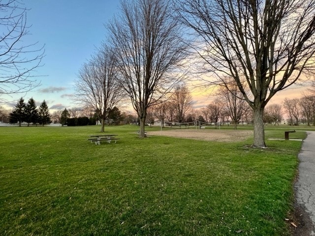 surrounding community featuring a lawn and volleyball court