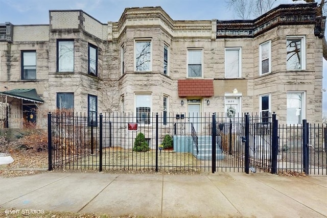 view of property with a fenced front yard and stone siding