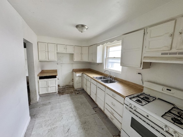 kitchen with under cabinet range hood, gas range gas stove, marble finish floor, and a sink