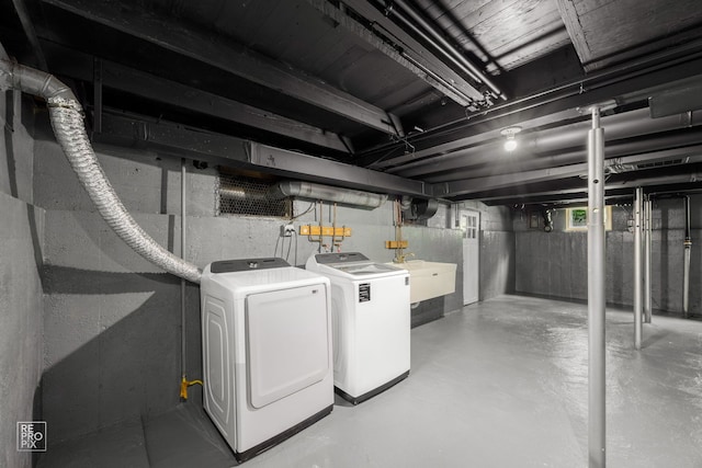 below grade area featuring separate washer and dryer and a sink