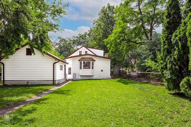 back of property with a yard and fence