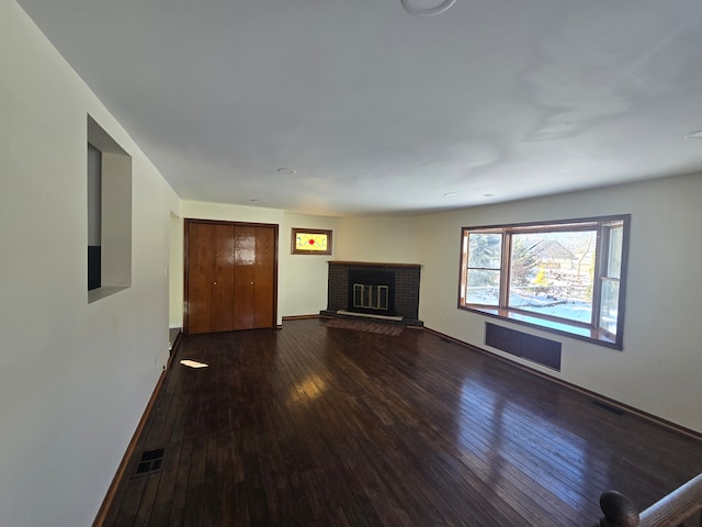 unfurnished living room featuring visible vents, wood-type flooring, baseboards, and a fireplace