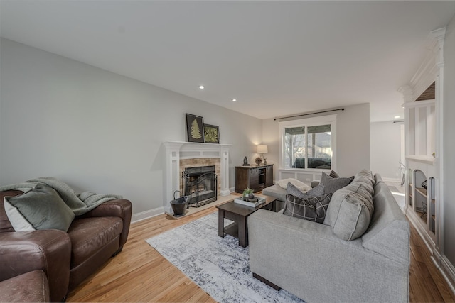 living room with recessed lighting, wood finished floors, baseboards, and a tile fireplace