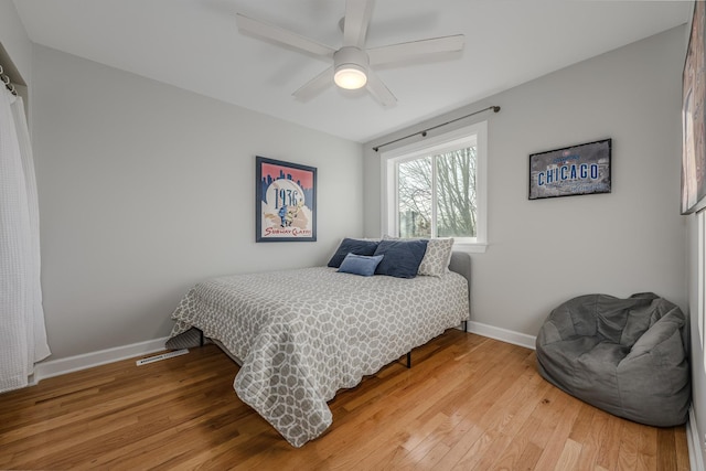 bedroom featuring baseboards, light wood-style floors, and ceiling fan