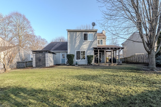 back of property with a storage unit, a lawn, a fenced backyard, an outdoor structure, and a chimney