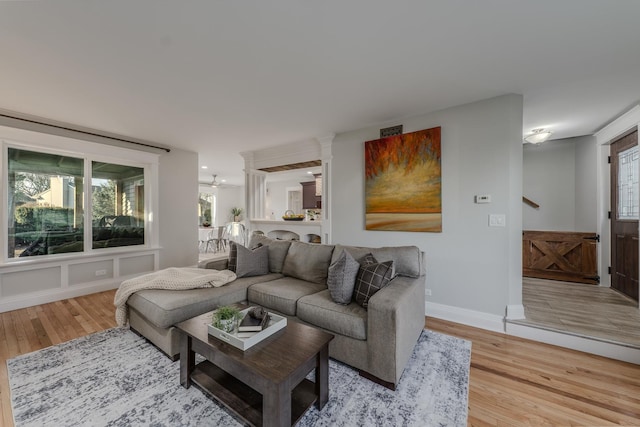 living room with light wood-style floors, baseboards, and a healthy amount of sunlight