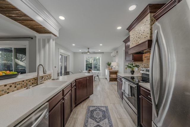 kitchen featuring dark brown cabinets, a wall mounted air conditioner, light countertops, appliances with stainless steel finishes, and a sink