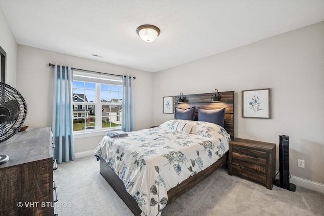 bedroom with visible vents, light carpet, and baseboards