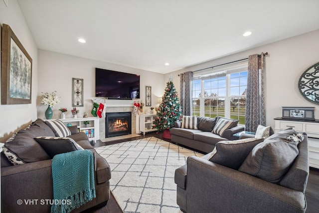 living room with recessed lighting, wood finished floors, and a tile fireplace