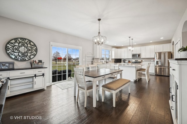 dining space featuring recessed lighting, a notable chandelier, and dark wood-style flooring