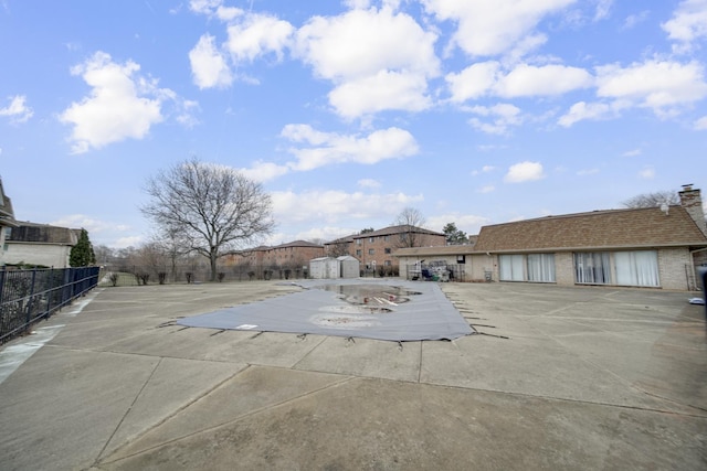 view of swimming pool featuring a patio, an outdoor structure, a shed, and fence