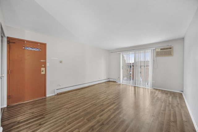 unfurnished living room featuring a wall unit AC, wood finished floors, baseboards, and a baseboard radiator