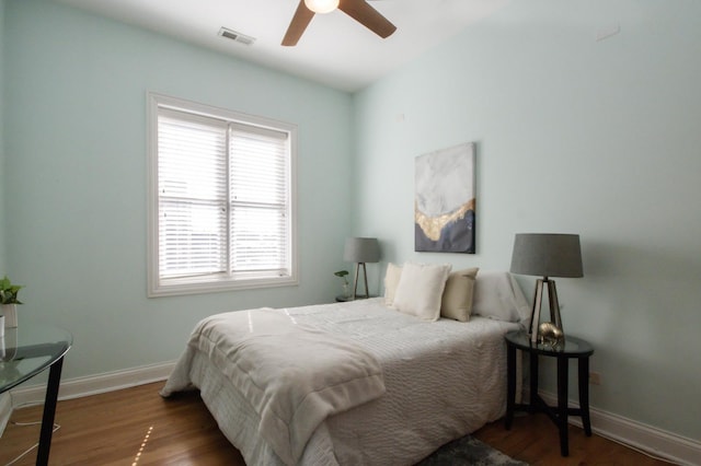 bedroom featuring visible vents, wood finished floors, baseboards, and ceiling fan