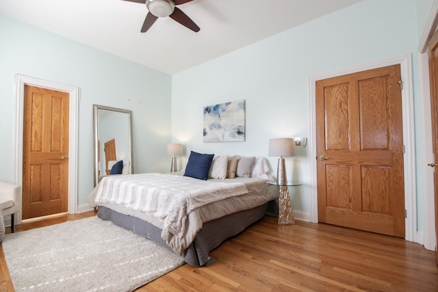 bedroom with ceiling fan, baseboards, and light wood-style floors