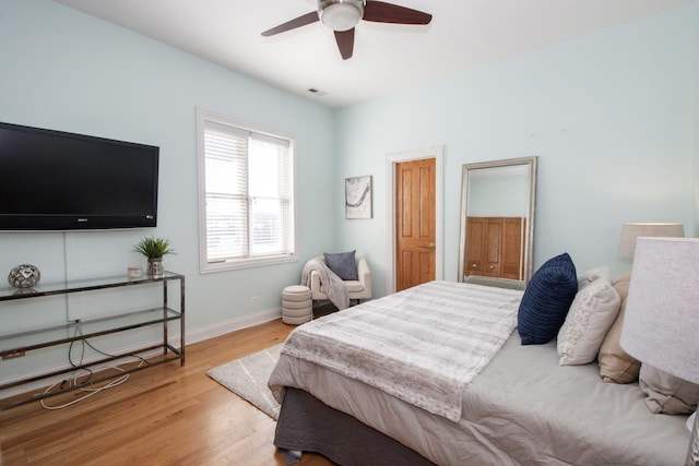 bedroom featuring light wood-style flooring, baseboards, visible vents, and ceiling fan