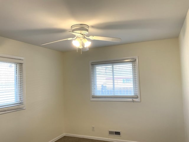 spare room with visible vents, baseboards, and ceiling fan