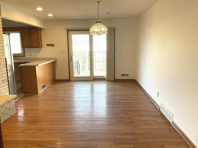 unfurnished dining area featuring visible vents, recessed lighting, and hardwood / wood-style floors