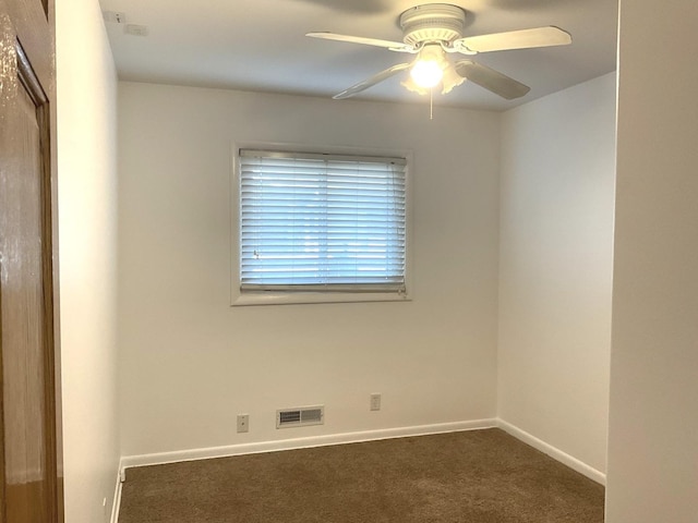 carpeted spare room featuring visible vents, baseboards, and a ceiling fan