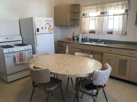 kitchen featuring wallpapered walls, white appliances, open shelves, and a sink