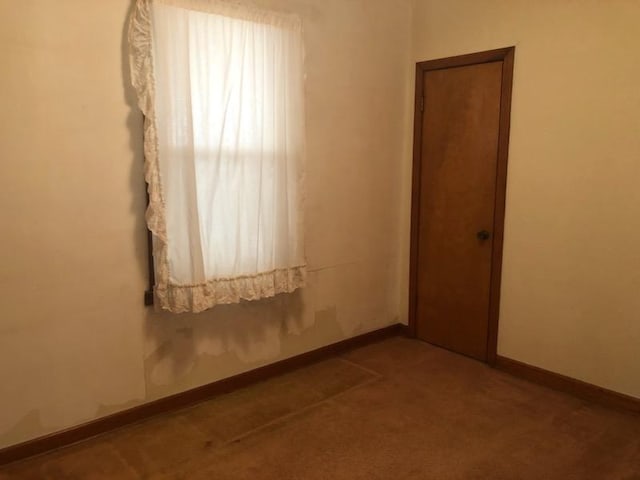 carpeted spare room featuring baseboards