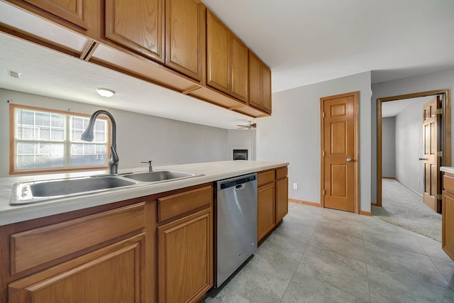 kitchen with a sink, brown cabinets, stainless steel dishwasher, and light countertops